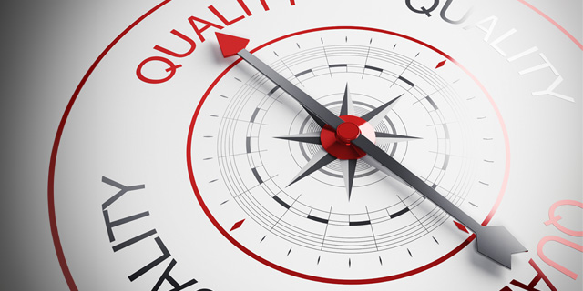 A compass showing the needle pointing to text "quality"